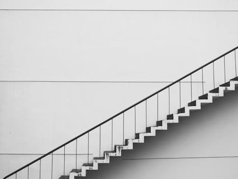 Minimalistic black and white staircase with sharp angles and clean lines, showcasing modern architecture.
